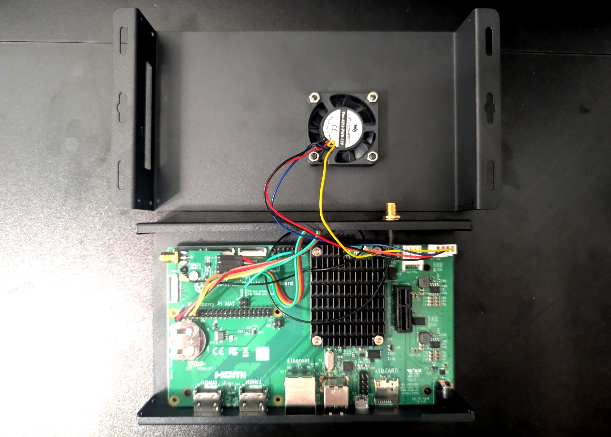 Case lid removed showing the IO board, wiring, and fan